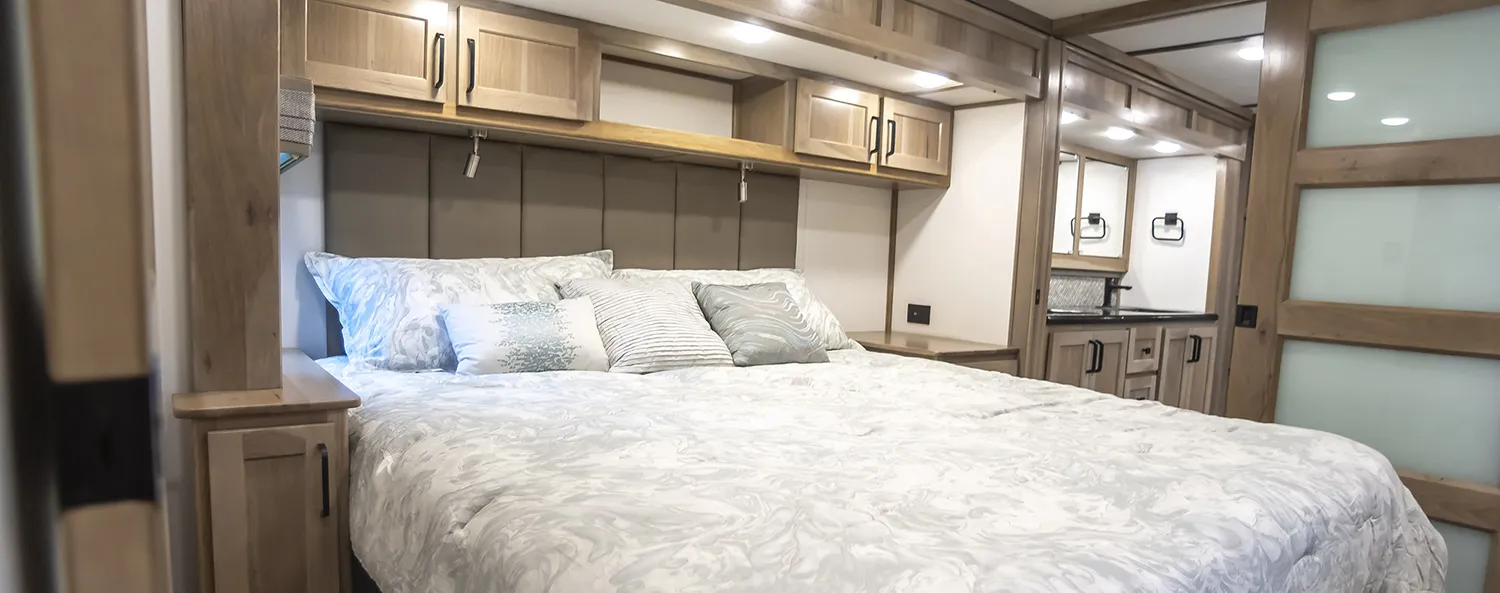 A comfortable bedroom in a luxury fifth wheel built by Luxe Fifth Wheel out of Elkhart Indiana.