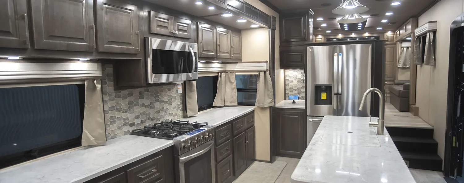 The kitchen of a Luxe Elite luxury fifth wheel with Brazilian cabinetry, built by Luxe Fifth Wheel out of Elkhart Indiana.