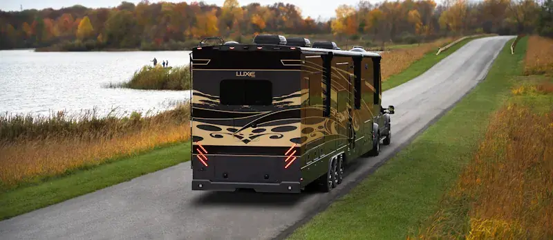 luxe-luxury-fifth-wheel-driving-through-state-park A Luxe Luxury Fifth Wheel Toy Hauler driving through a state park.